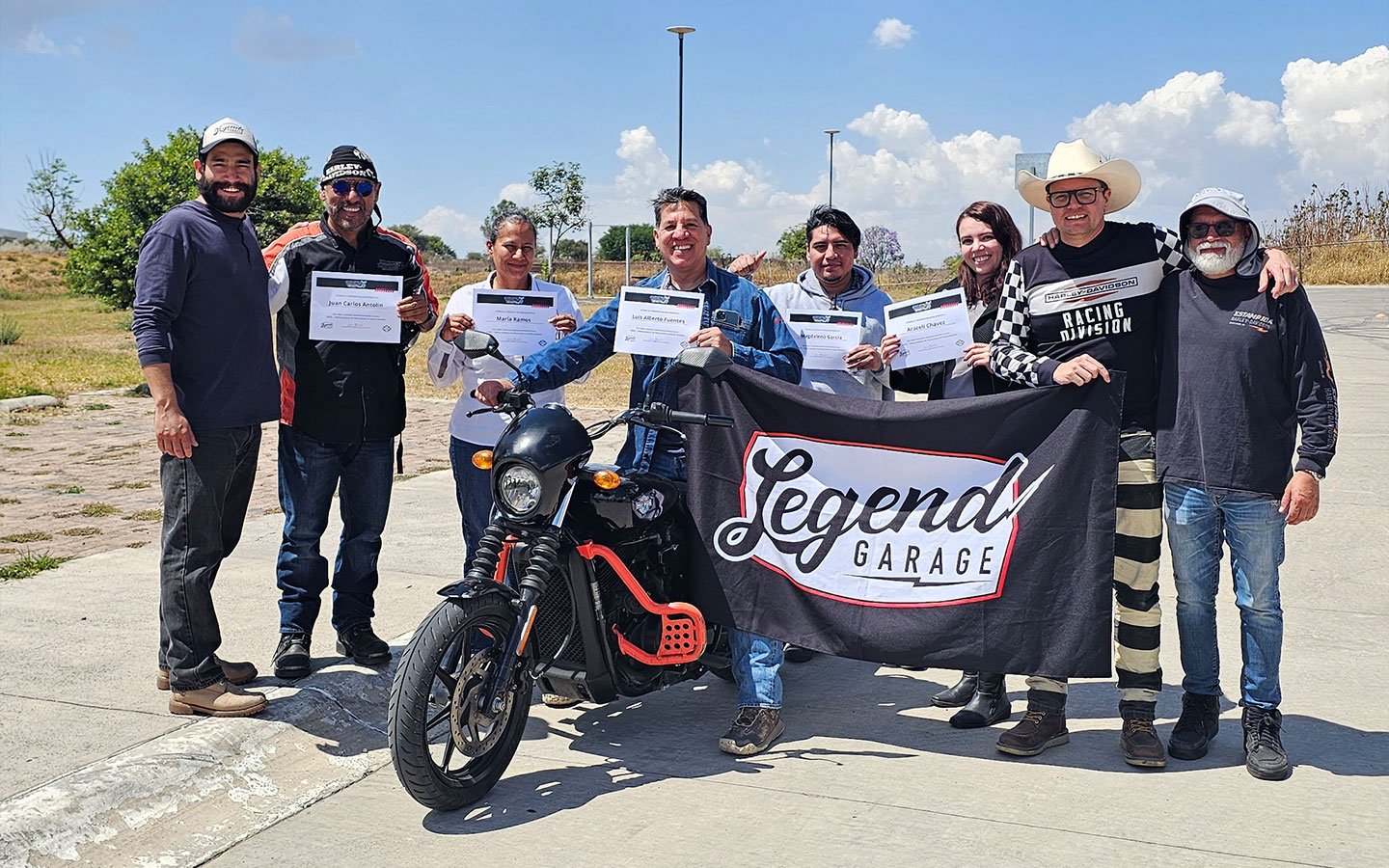Grupo de alumnos con instructores y motocicleta de Legend Garage